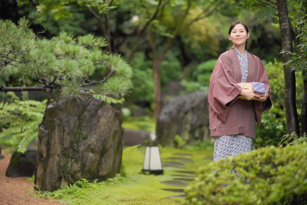 Woman in a yukata walking through a garden at a Ryokan Japan