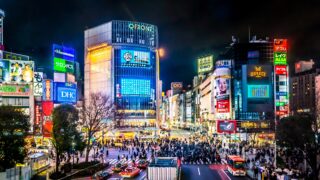 Night view of tokyo Shibuya Crossing with neon-lit buildings.