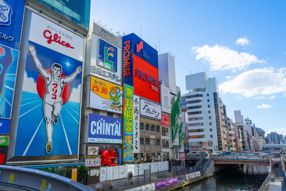 The famous Glico Running Man sign illuminated at night in Dotonbori, Osaka.