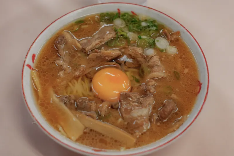 A hearty bowl of Tokushima Ramen with pork and raw egg