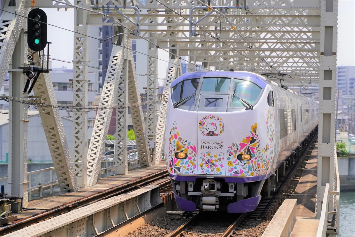 JR Haruka train with Hello Kitty designs, traveling from Kansai Airport to Kyoto.
