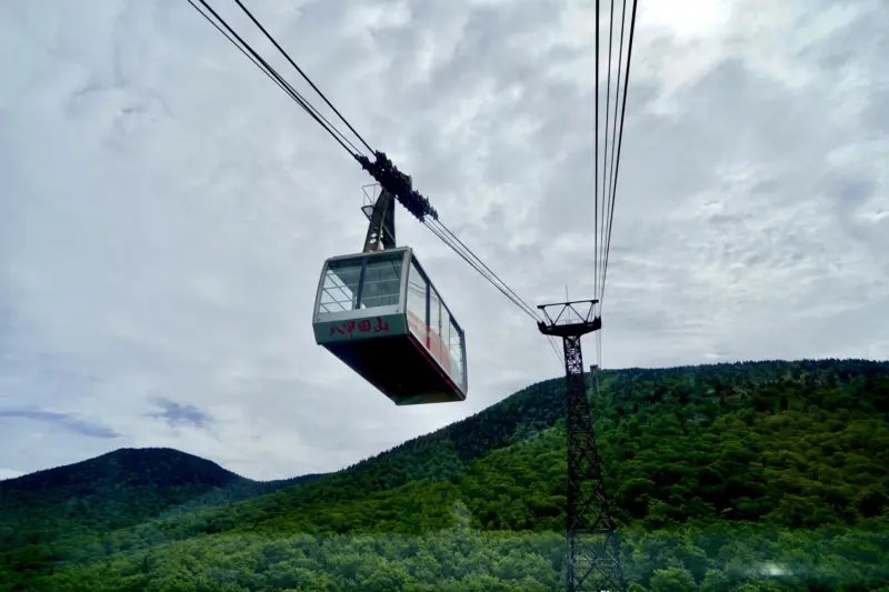 A ropeway car ascending the snowy Hakkoda Mountains.
