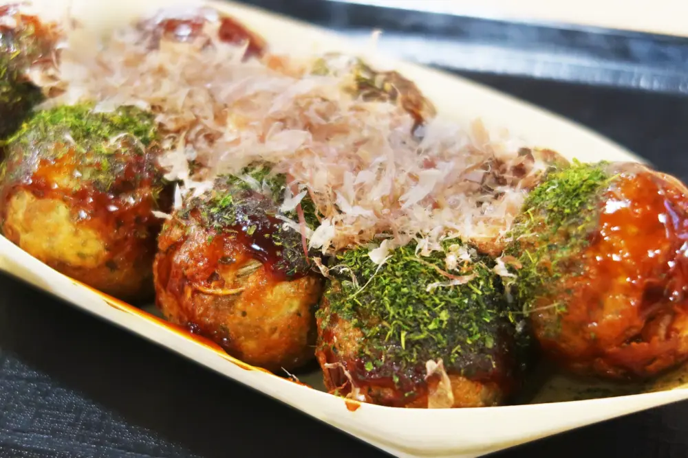 Freshly cooked takoyaki with toppings at a street vendor