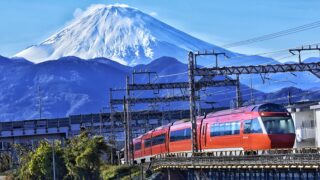 An orange Odakyu Romancecar traveling from Tokyo to Hakone, a scenic and convenient train ride.