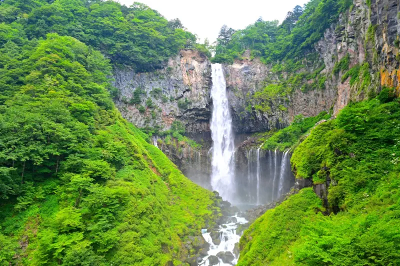 Kegon Falls in Nikko cascading into a lush green basin