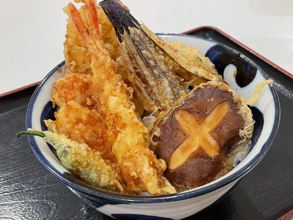 A tempura bowl topped with crispy vegetable tempura at Tendon Tenya, perfect for veggie lovers.