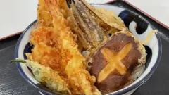 A tempura bowl topped with crispy vegetable tempura at Tendon Tenya, perfect for veggie lovers.