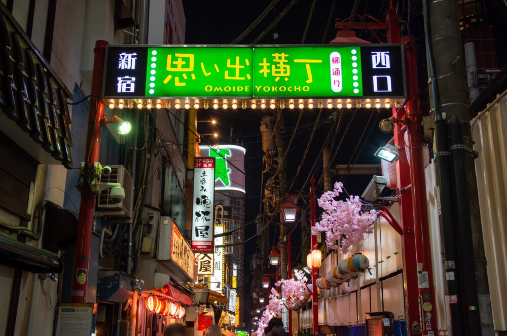 The illuminated entrance sign of Omoide Yokocho at night, preserving the memory of old Tokyo