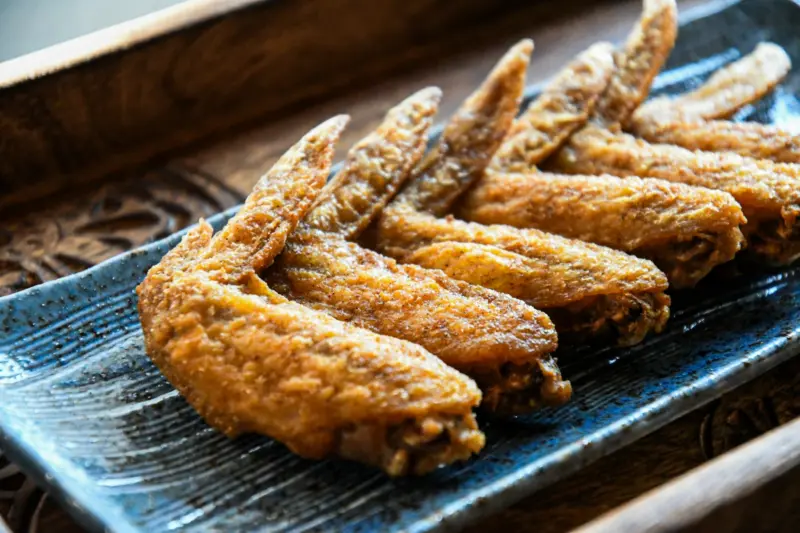  Crispy chicken wings with sesame seeds on a plate
