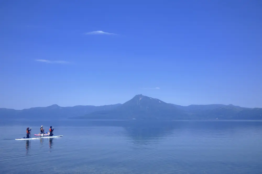 Visitors kayaking on the crystal-clear waters of Lake Shikotsu.