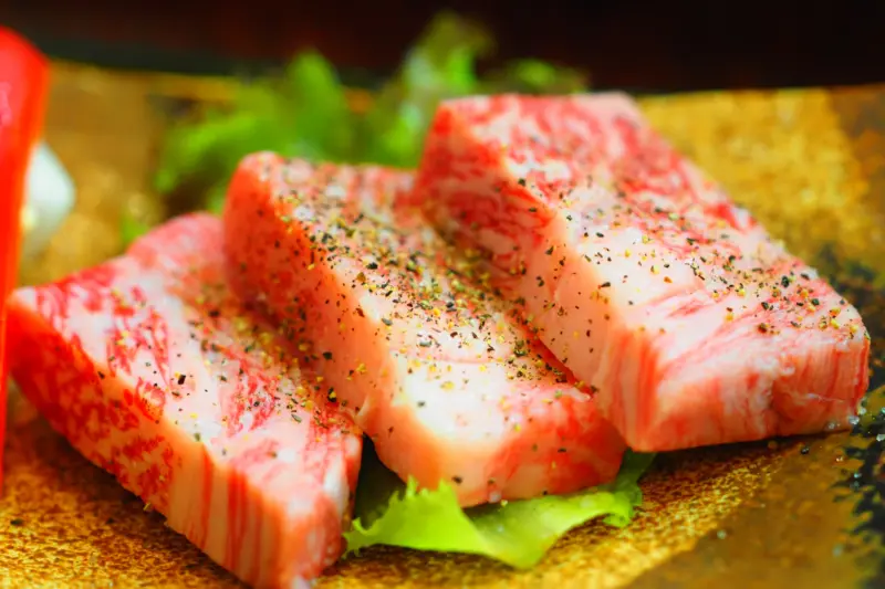 Juicy slices of Maesawa Beef being grilled to perfection