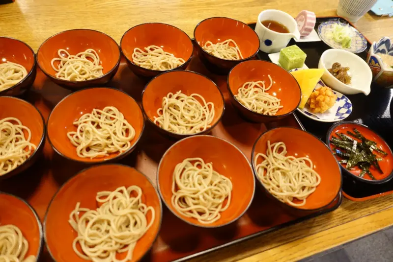 Small bowls of Wanko Soba arranged on a traditional wooden tray