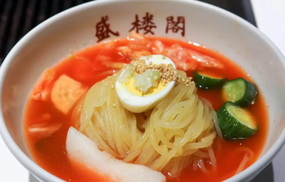 served with tender beef slices, a boiled egg, and refreshing broth.