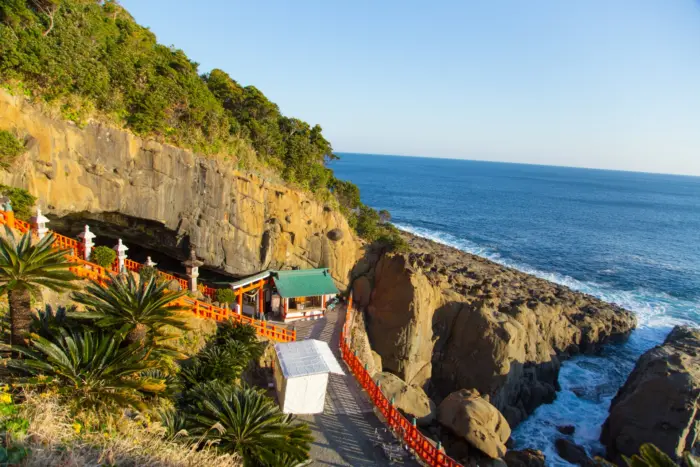 The vibrant red torii gates and coastal cave setting of Udo Jingu Shrine in Miyazaki.