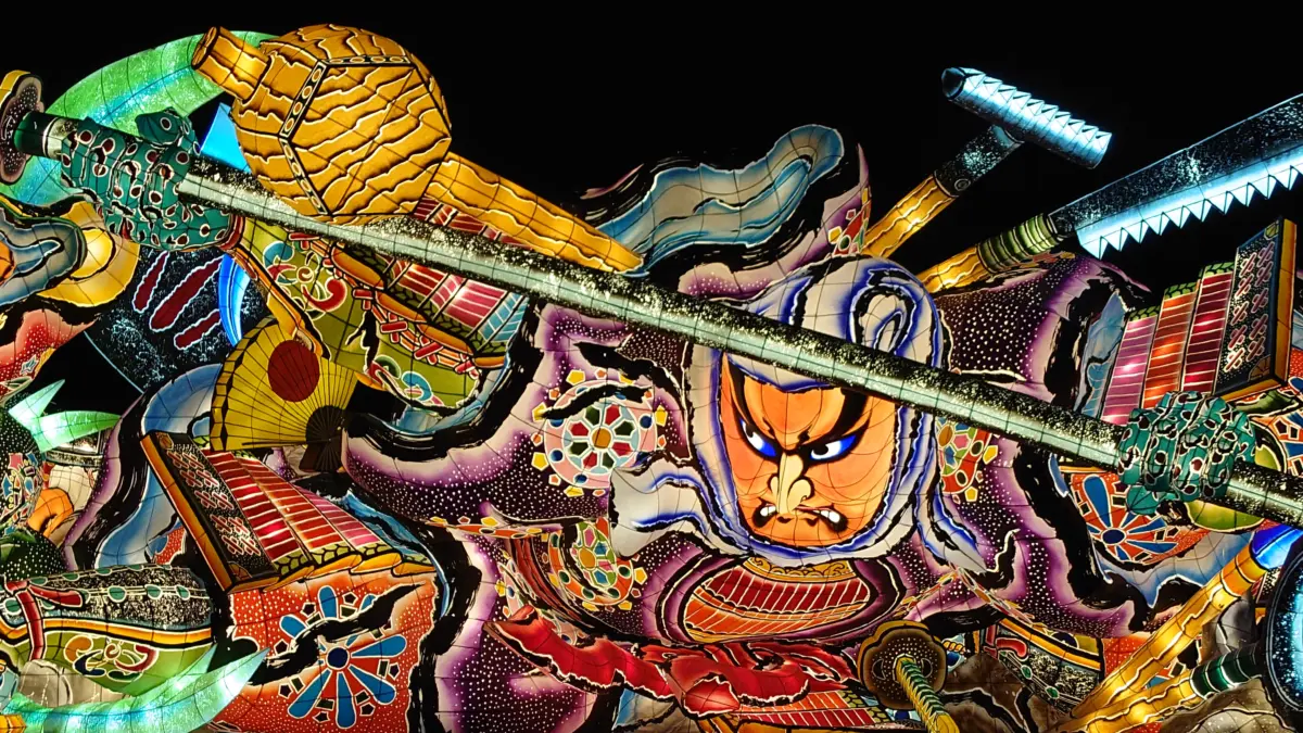 Large illuminated floats paraded during the Nebuta Matsuri in Aomori, Japan, showcasing vibrant colors and traditional designs.