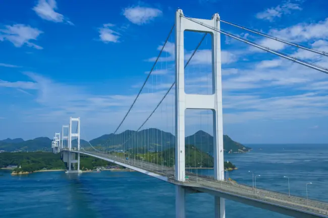 A cyclist crossing a bridge on the Shimanami Kaido with stunning views of the Seto Inland Sea