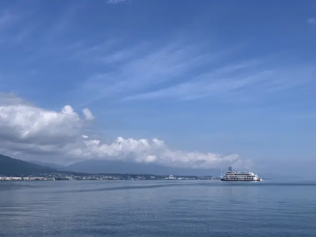 A scenic view of Lake Biwa with Shirahige Shrine’s torii gate standing in the water.