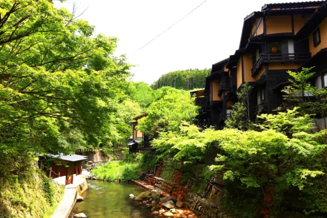 A rustic outdoor bath surrounded by nature at Kurokawa Onsen in Kumamoto Prefecture