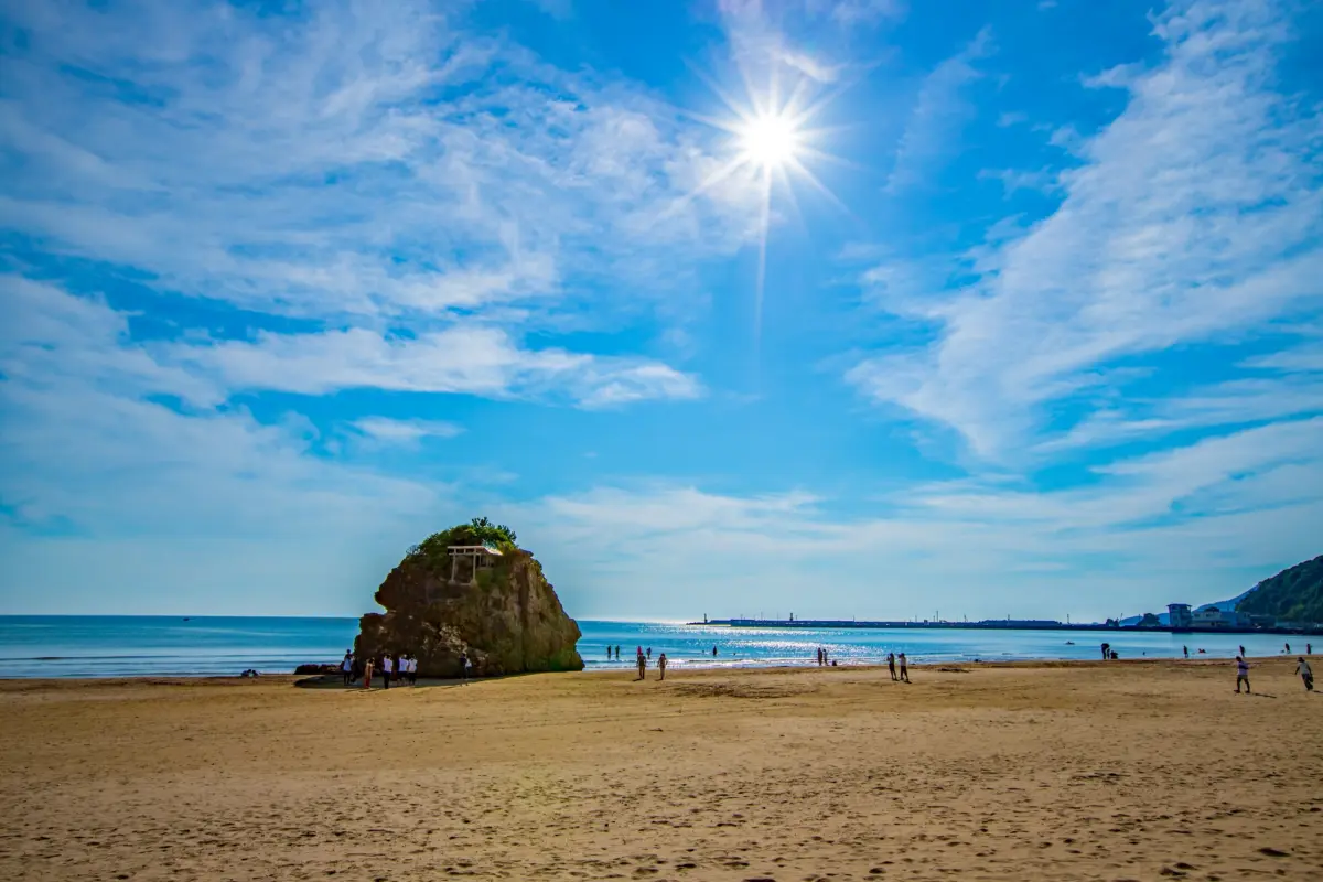 Sunset over Inasa Beach with the sacred Bentenjima rock in Shimane, Japan.
