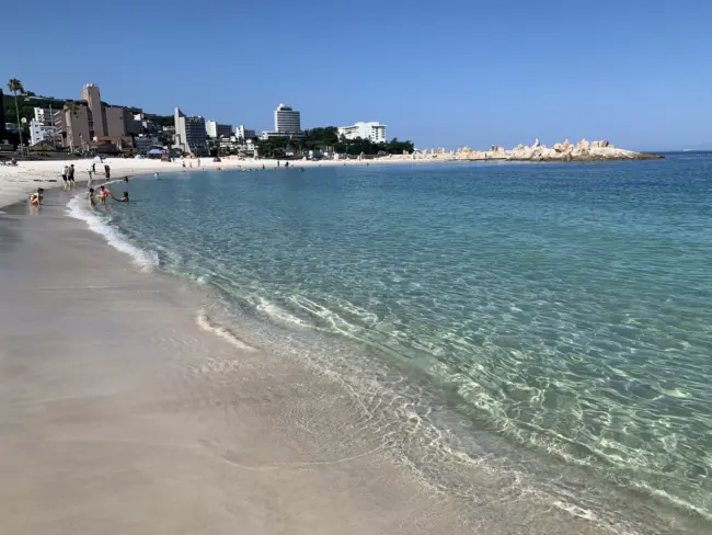 Shirahama's white sand beach with clear blue water and nearby Sandanbeki cliffs