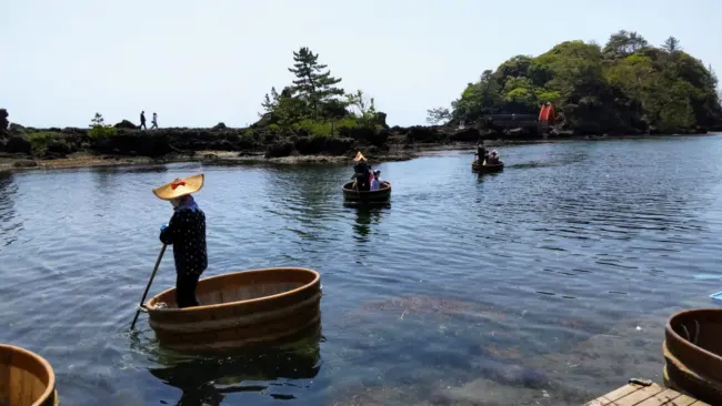 Traditional tarai-bune boats gliding along Sado Island’s serene waters.