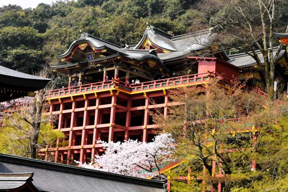 The iconic red structure of Yutoku Inari Shrine surrounded by lush greenery.