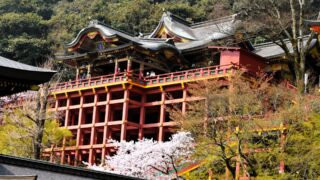 The iconic red structure of Yutoku Inari Shrine surrounded by lush greenery.