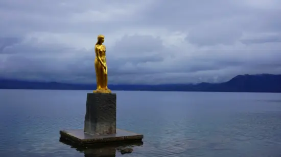 Lake Tazawa, featuring its iconic golden Tatsuko Statue and crystal-clear waters.