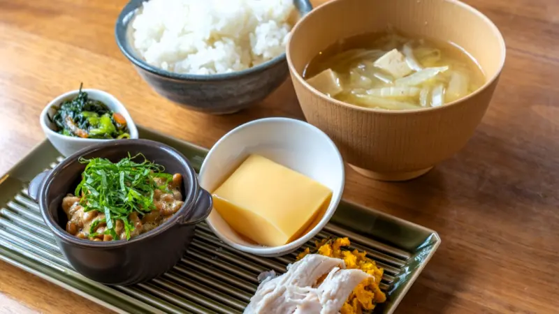  A beautifully plated washoku meal with rice, miso soup, pickles, and grilled fish.