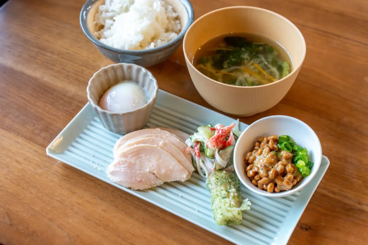 A traditional Japanese breakfast featuring grilled salmon, natto, rice, and miso soup, representing Japanese Cuisine washoku.