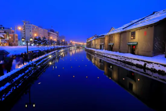 The scenic Otaru Canal, surrounded by historic buildings and glowing lanterns.