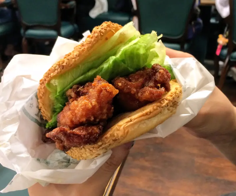 A giant Chinese Chicken Burger with crispy fried chicken and savory sauce.