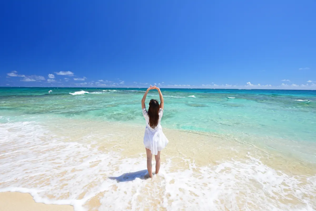 A woman enjoying the beach on Marine Day, a Japanese holiday celebrating the ocean's importance and its blessings.