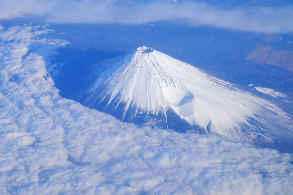  A majestic view of Mount Fuji, part of Japan UNESCO World Heritage Sites, with a serene lake in the foreground.