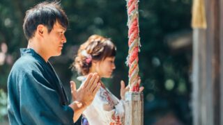 A woman respectfully praying at a Shinto shrine, demonstrating traditional Japanese customs.