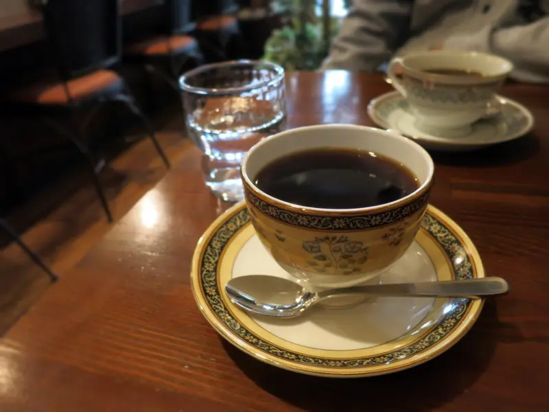  A cozy retro café interior with vintage décor and coffee served in porcelain cups.