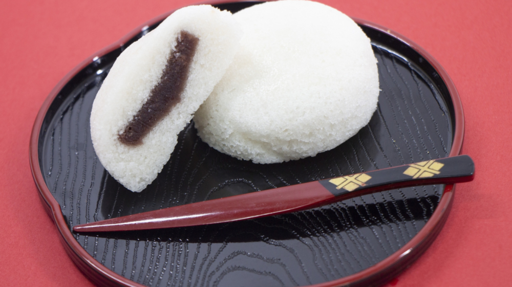 A small, round steamed wagashi filled with sweet red bean paste.