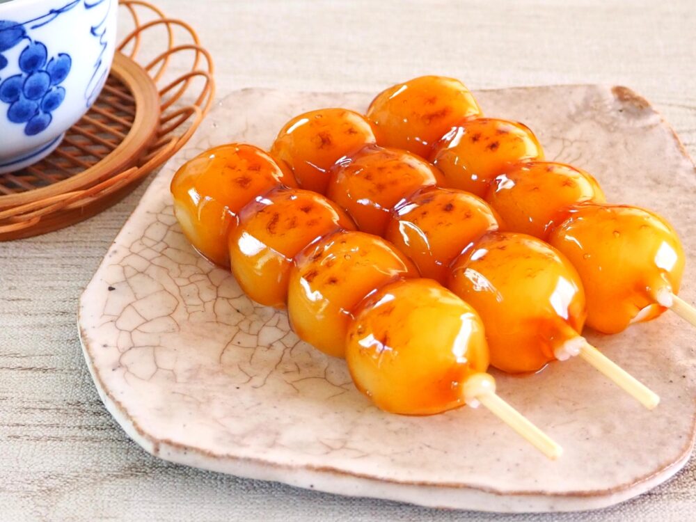 Skewered wagashi made of sweet rice dumplings, often with sauce.
