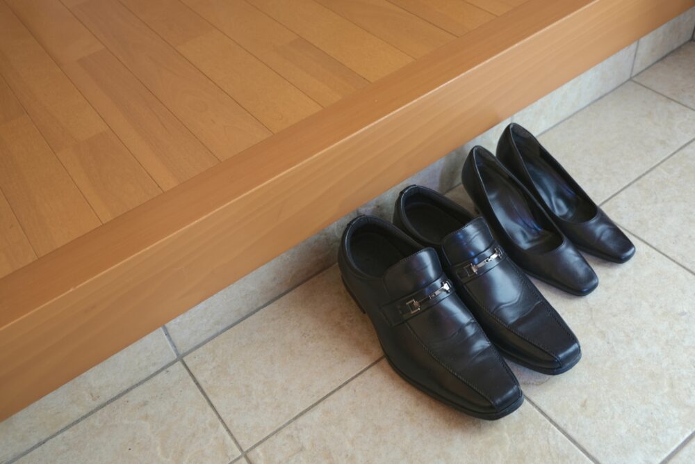 A row of neatly placed shoes at the entrance of a traditional Japanese home.