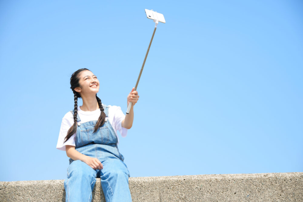 A person using a selfie stick with a smartphone.