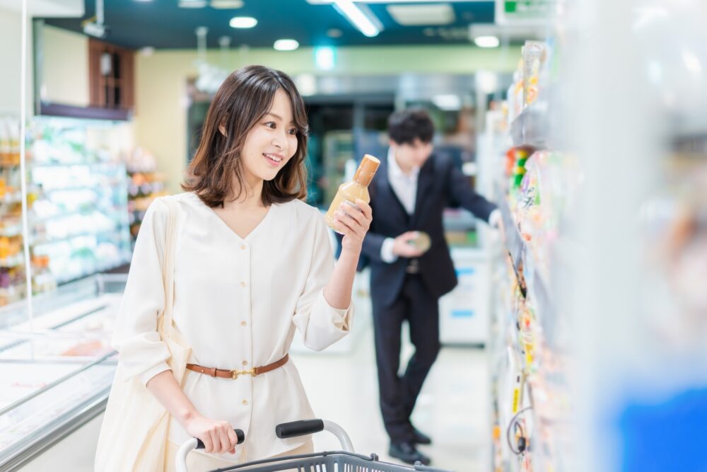 A Japanese convenience store shelf stocked with fresh onigiri, bento, and snacks.
