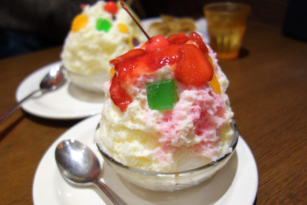 A bowl of Shirokuma Ice topped with fruit and condensed milk
